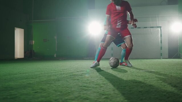 Football club, young guys play football indoor stadium, man bypass the opponent and scores a goal, low angle view, 4k slow motion.