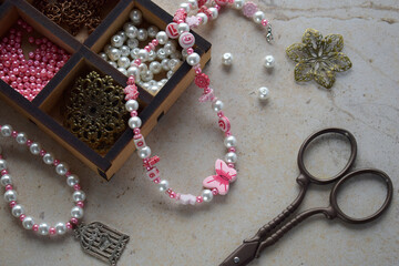Making the jewelry. Needlework accessories for creating bracelet, chain from beads. DIY project. Small business. Income from hobby.