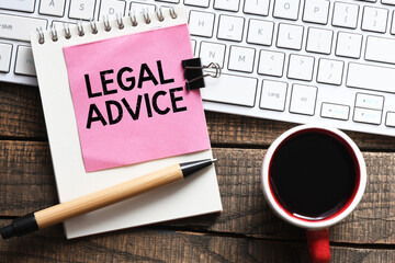 LEGAL ADVICE words on a small sheet of paper placed on a notebook.