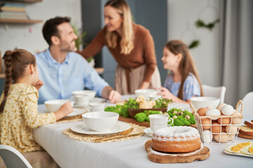 Caucasian family of four celebrating over easter table