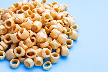 Crispy potato rings on blue background.