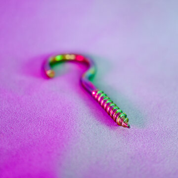 Yellow python screw. Screw with hook-shaped back. Focus is on the front.