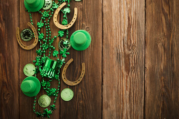 Fototapeta premium St Patricks Day border of shamrocks beads and coins over a rustic wood background
