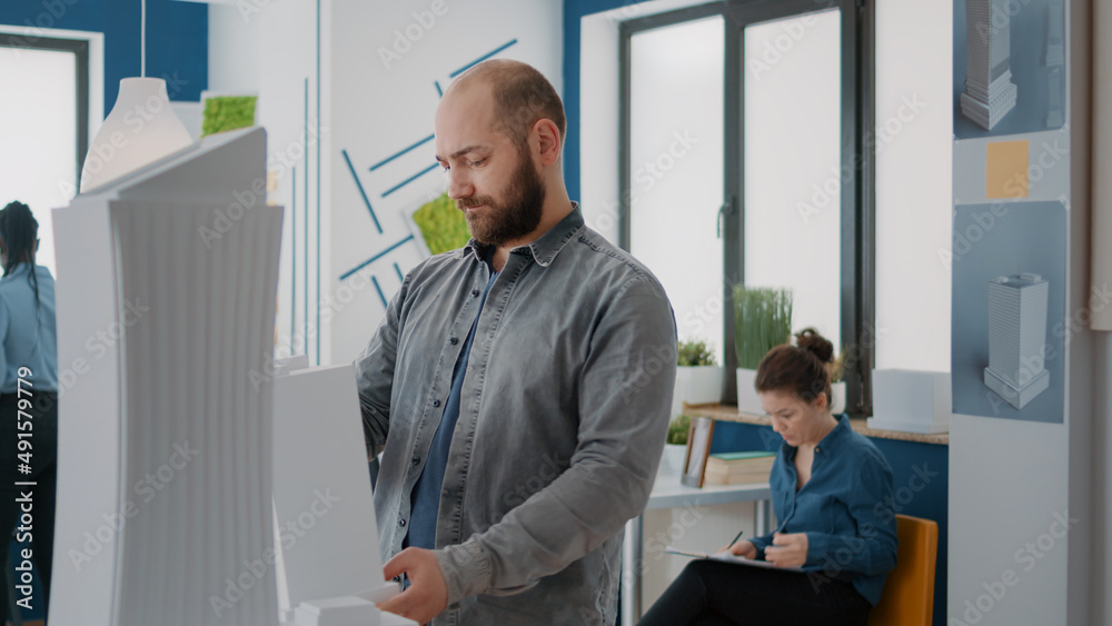 Poster portrait of architect holding building model to create architectural project and structure. man buil