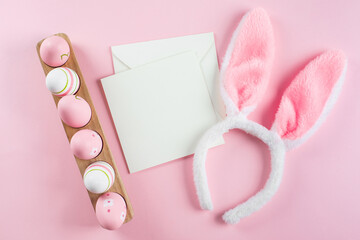 Easter eggs, fluffy bunny ears, white empty card for congratulations. Mockup. Easter holiday concept