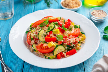 Tabbouleh salad with avocado and quinoa on a blue background.