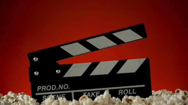 Clapperboard popcorn on red background