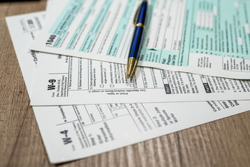 many us tax form 1040 w4 w9 on office desk. financial documents