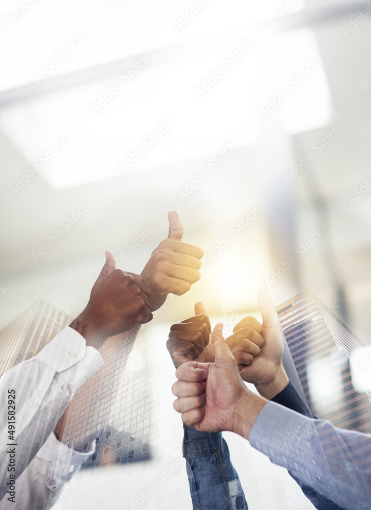 Poster feeling great about teamwork. shot of skyscrapers superimposed over an unidentifiable business team 