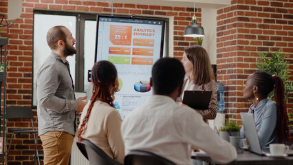 Team of coworkers receiving applause from people at briefing meeting in office. Colleagues clapping hands and celebrating achievement, feeling cheerful about successful presentation and win.