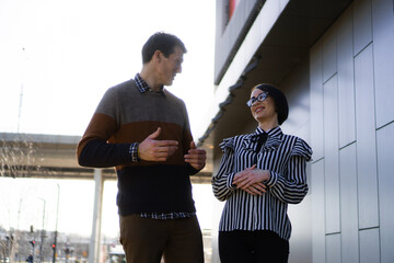 Two Casual business people smiling while talking and looking at each other