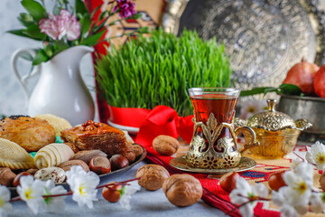 Traditional Azerbaijan spring holiday Novruz tray with semeni - wheat grass, pakhlava, shekerbura,badambura,mutaki,gogal,flowers,dry fruits,spring flowers.