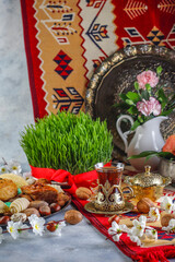 Traditional Azerbaijan spring holiday Novruz tray with semeni - wheat grass, pakhlava, shekerbura,badambura,mutaki,gogal,flowers,dry fruits,spring flowers.