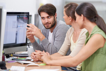 Working together to make the project a success. Shot of a group of young businesspeople talking at their desk.