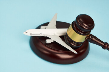 Aviation law concept. Judge gavel and airplane on blue background - obrazy, fototapety, plakaty