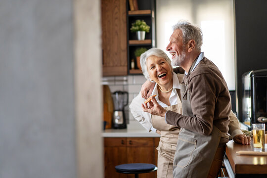 Happy senior couple communicating while having fun in the kitchen together