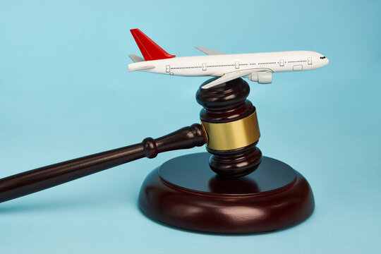 Aviation law concept. Judge gavel and airplane on blue background
