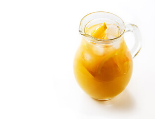 Jug of tasty cold juice from grapefruit or orange, refreshing drink with ice isolated on white background. Refreshing summer cocktail, selective focus.