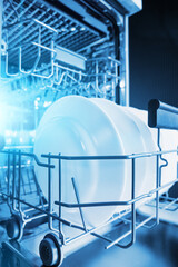 Clean plates after washing in the dishwasher. Close-up of the dishes placed in the dishwasher