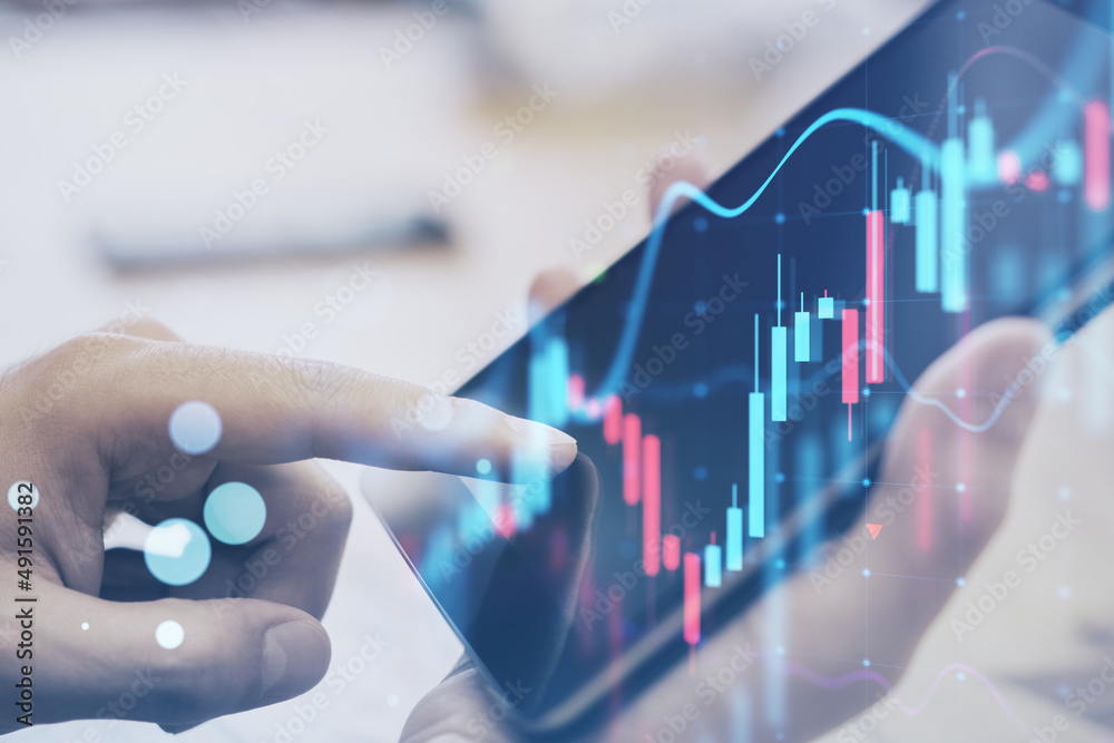 Poster close up of hand using digial tablet at desktop with glowing forex chart on blurry background. trade