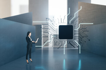 Attractive european businesswoman with laptop standing in concrete interior with abstract micro...