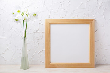  Square wooden picture frame mockup with lily in the glass vase