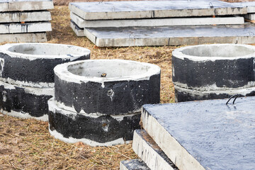 Reinforced concrete rings and slabs for wells on the construction site. Preparation for the device of underground wells and communications. Close-up.