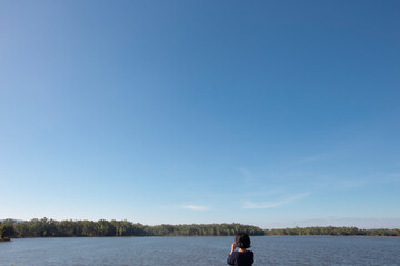 Obraz na płótnie Canvas Woman taking a camera in .lake