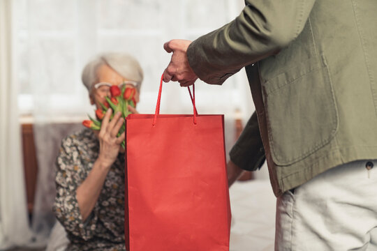 European man giving his mother a present for upcoming Mother's Day . High quality photo