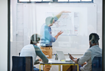 Designing the office of tomorrow. Cropped shot of a group of architects discussing plans.