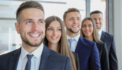 Happy smiling business team standing in a row at office