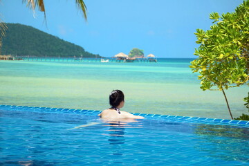 Woman swimming in the pool by the sea.Swimming pool by the sea. Phuket beach. Pattaya beach. Pool View.
