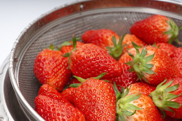 Fresh strawberries in a basket over white background