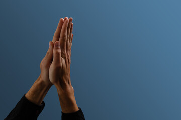Praying hands with faith in religion and belief in God on dark background. Power of hope or love and devotion. Namaste or Namaskar hands gesture. Prayer position