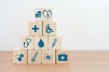 flipped wood cube block on top of pyramid with health and medical icon, elderly in heart and money symbol on top for retirement, elderly care, health and medical concept