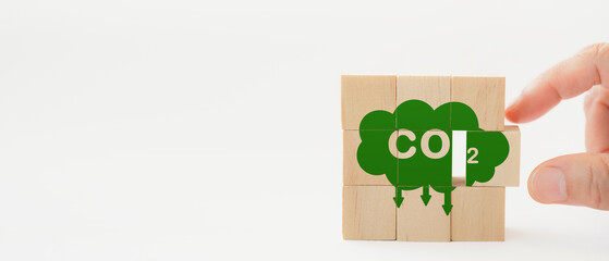 Hand completed the wooden cubes with CO2 emission reduction icon for  CO2 emission ,green industries business . Net zero emissions. renewable energy, sustainable technology, ecology solutions concept - obrazy, fototapety, plakaty