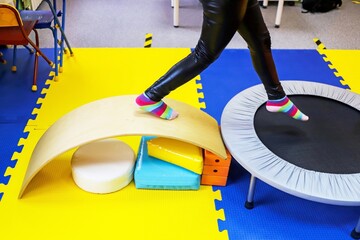 an autistic girl is treated in the form of a game by a psychologist, exercises on the ballancer help the brain, balance - obrazy, fototapety, plakaty
