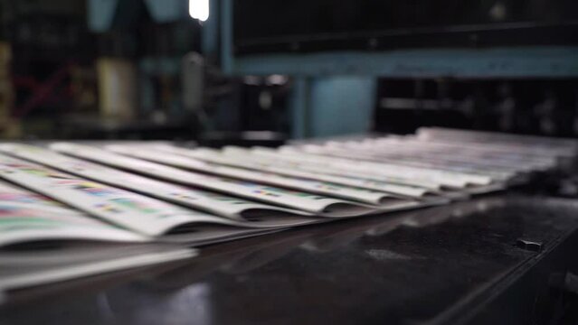 Printed newspapers are moved along conveyor. Printing house. Printed publications, newspapers fall on conveyor belt and move along it. Media, article, daily news, print edition, journalism, politics