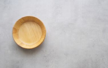 Empty round wooden plate on gray cement table background, banner with copy space, Blank wood tray for food display montage, template, mock up, top view, flat lay