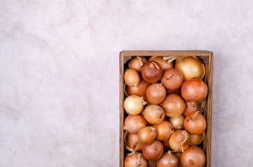Fresh yellow onions in a wooden box