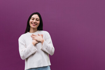 Portrait of happy nice looking asian woman hugs herself, expresses natural positive emotions