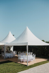 Table setting at a luxury event and beautiful flowers on the table. Beautiful wedding arch of flowers.