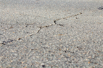 Asphalt road with cracks, close-up, backdrop or advertising background