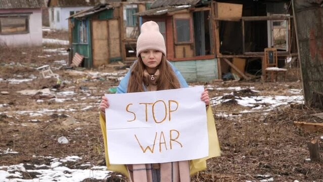 Upset Ukrainian poor girl kid protesting war conflict raises banner with inscription massage text Stop War. Crisis, peace, stop aggression, child against Russian war