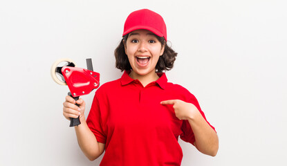 pretty hispanic girl feeling happy and pointing to self with an excited. packer concept