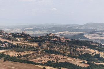 Fototapeta na wymiar Panoramic view of the province of Tuscany with the city Castiglione d'Orcia on top of the hill and the tower Rocca di Tentennano. Val d'Orcia, Italy