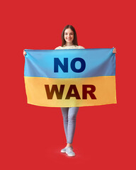 Young woman holding Ukrainian flag with text NO WAR on red background