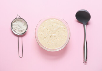 Raw batter with flour and ladle on color background