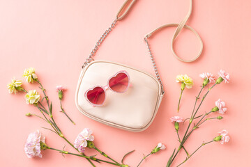 Fashion spring accessories - white handbag, sunglasses and flowers on pastel pink