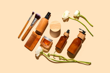 Set of cosmetic products, hair comb, makeup brushes and ranunculus flowers on color background